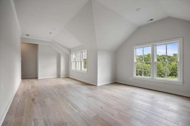 bonus room with light wood-type flooring, visible vents, vaulted ceiling, and baseboards