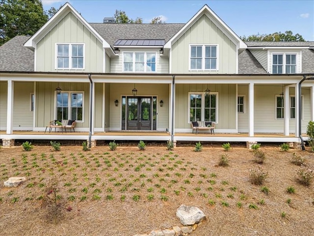 view of front of property with a porch, board and batten siding, and roof with shingles