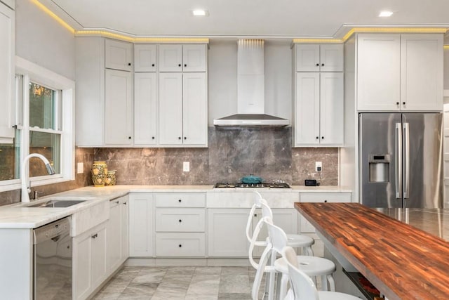 kitchen featuring white cabinetry, appliances with stainless steel finishes, sink, and wall chimney exhaust hood