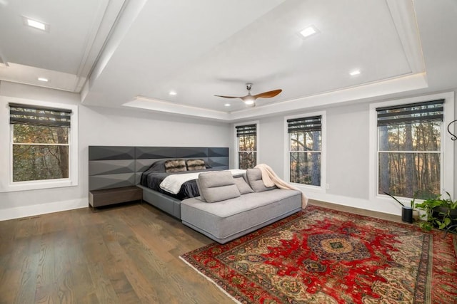 bedroom featuring a tray ceiling, ceiling fan, and dark hardwood / wood-style flooring