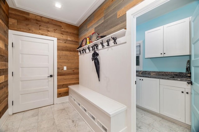 mudroom featuring wood walls