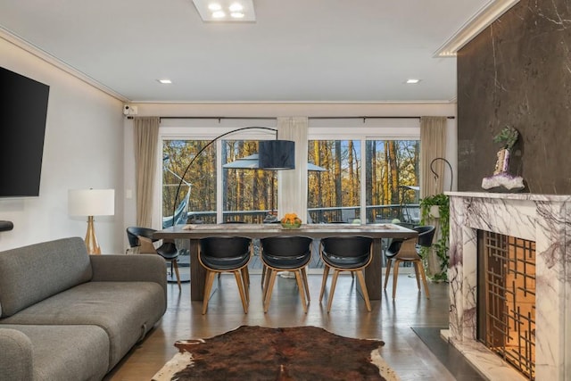 living room featuring ornamental molding, a high end fireplace, and light hardwood / wood-style flooring