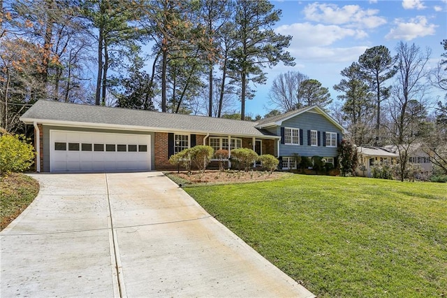 tri-level home with a garage, driveway, a front lawn, and brick siding