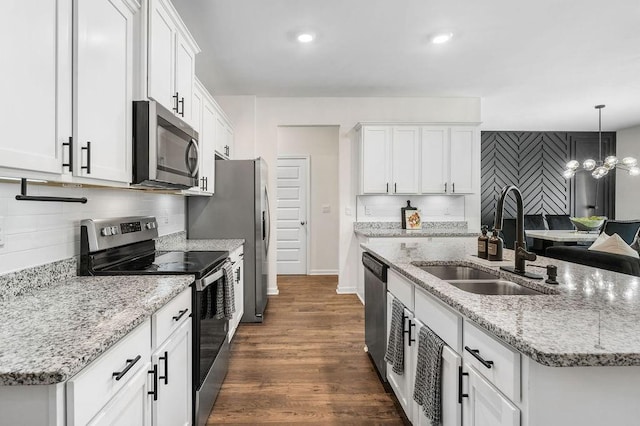 kitchen with white cabinetry, sink, stainless steel appliances, an inviting chandelier, and an island with sink