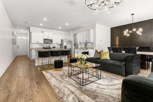 living room featuring a chandelier and light hardwood / wood-style floors