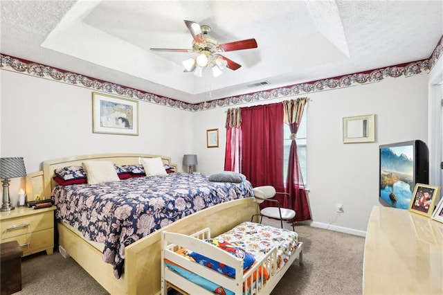 179 Parkside Dr, Stockbridge, GA 30281 - carpeted bedroom featuring a tray ceiling and a ceiling fan