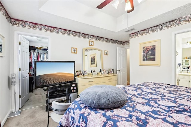 179 Parkside Dr, Stockbridge, GA 30281 - bedroom featuring a walk in closet, carpet, a closet, ensuite bathroom, and a tray ceiling