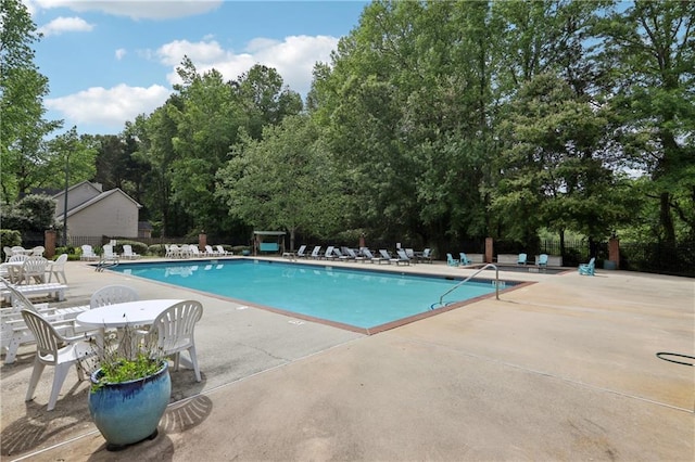 179 Parkside Dr, Stockbridge, GA 30281 - community pool featuring a patio and view of wooded area