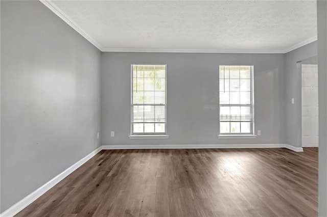 empty room with a wealth of natural light, ornamental molding, and dark hardwood / wood-style floors