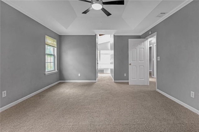 carpeted empty room with ceiling fan, ornamental molding, and a tray ceiling