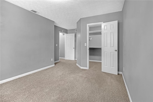 unfurnished bedroom featuring carpet floors, a closet, and a textured ceiling