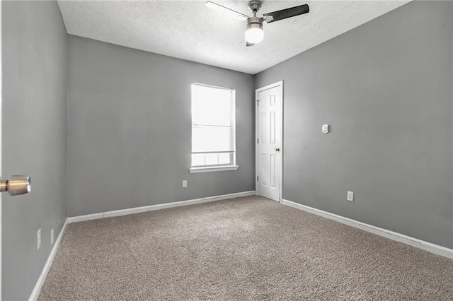 unfurnished room featuring ceiling fan, carpet floors, and a textured ceiling