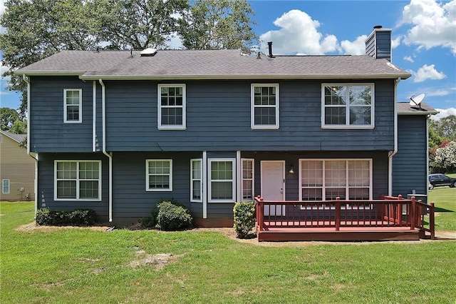 rear view of property with a wooden deck and a lawn