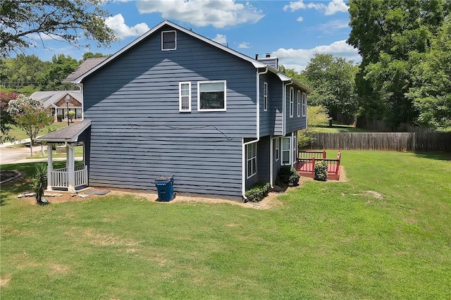 view of property exterior featuring a yard and a deck