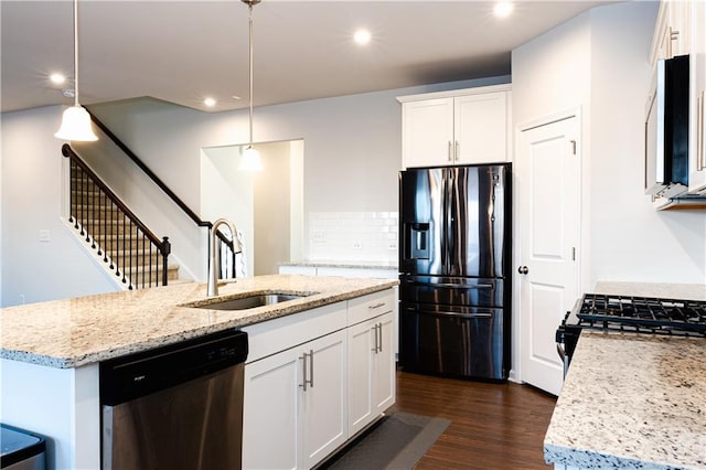 kitchen with sink, white cabinets, hanging light fixtures, a kitchen island with sink, and stainless steel appliances