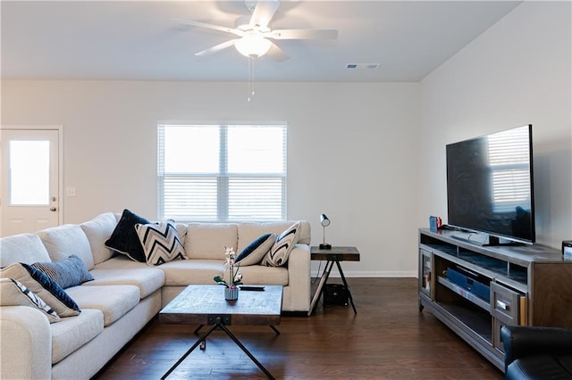 living room featuring dark wood-type flooring and ceiling fan