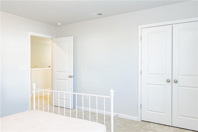 unfurnished bedroom with light carpet and a closet