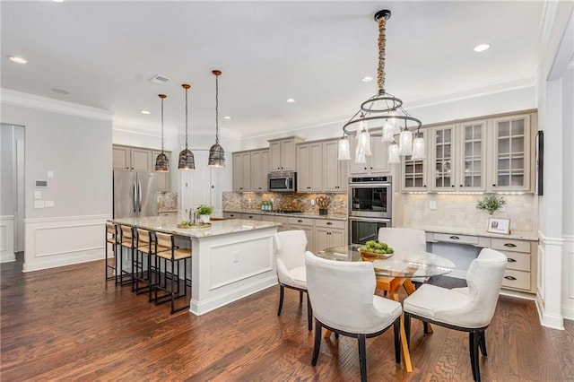 2544 Thompson Rd NE, Brookhaven, GA 30319 - kitchen featuring appliances with stainless steel finishes, a breakfast bar area, gray cabinetry, a kitchen island with sink, and tasteful backsplash
