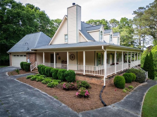 farmhouse inspired home with a garage and covered porch