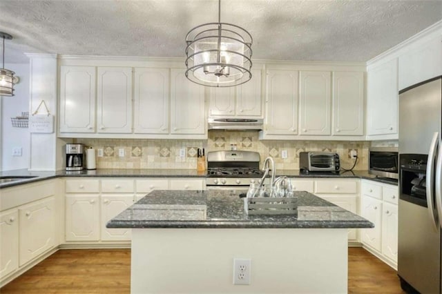 kitchen featuring stainless steel appliances, light hardwood / wood-style floors, decorative light fixtures, and a kitchen island