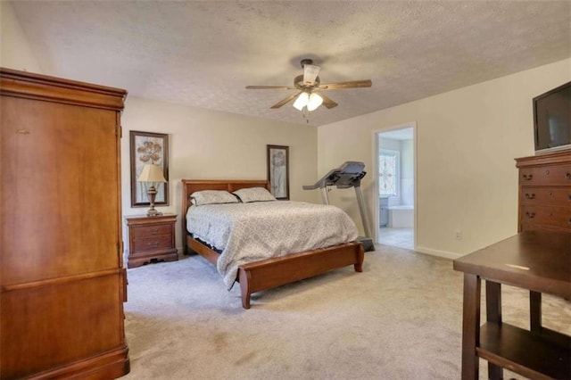 carpeted bedroom featuring ceiling fan, ensuite bath, and a textured ceiling