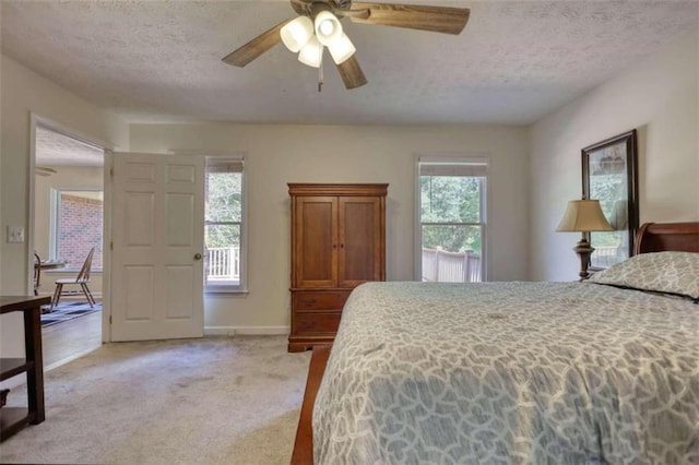 carpeted bedroom with a textured ceiling and ceiling fan