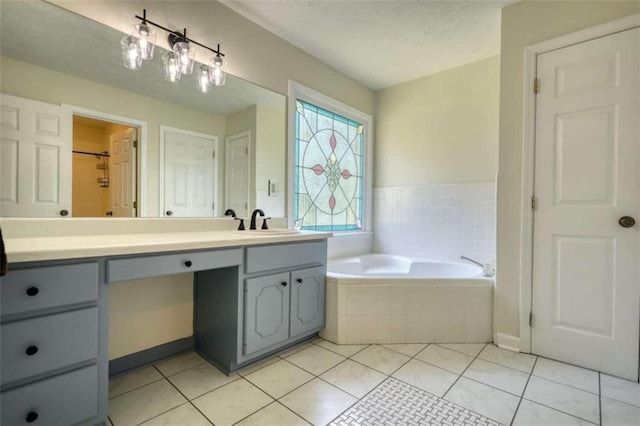 bathroom with vanity, tile patterned floors, a textured ceiling, and tiled tub