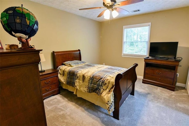 carpeted bedroom featuring a textured ceiling and ceiling fan