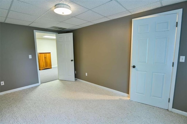 carpeted empty room featuring a paneled ceiling