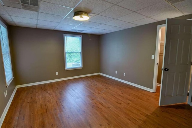 unfurnished room with a drop ceiling and hardwood / wood-style flooring