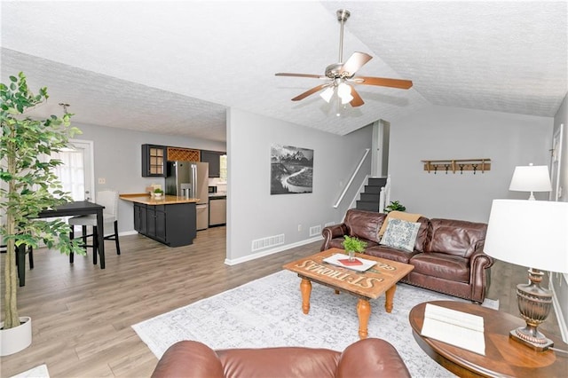 living room featuring a textured ceiling, ceiling fan, and hardwood / wood-style floors