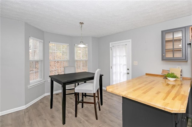 dining space with a textured ceiling and light wood-type flooring