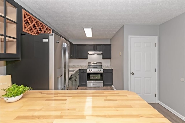 kitchen featuring appliances with stainless steel finishes, dark wood-type flooring, and a textured ceiling