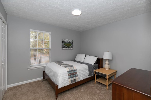 bedroom featuring a textured ceiling, a closet, and carpet