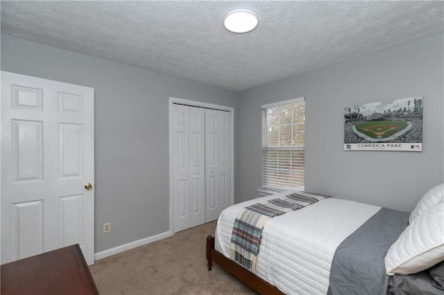 carpeted bedroom with a closet and a textured ceiling