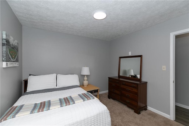 bedroom featuring carpet floors and a textured ceiling