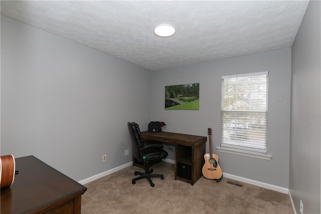 home office featuring a textured ceiling and light carpet