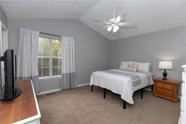 carpeted bedroom with ceiling fan, vaulted ceiling, and a textured ceiling