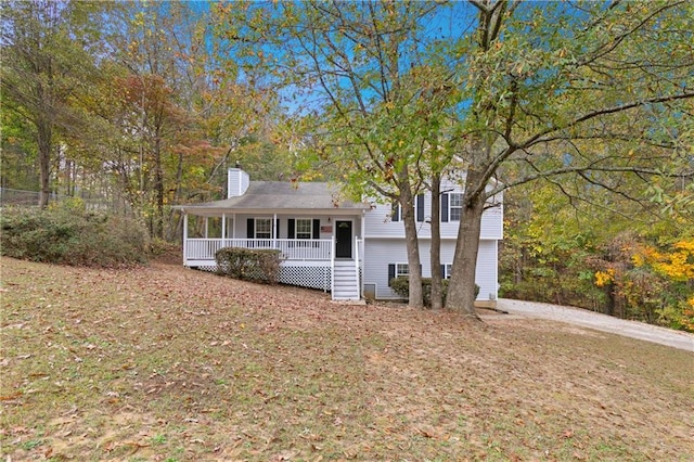 split level home featuring covered porch and a front lawn