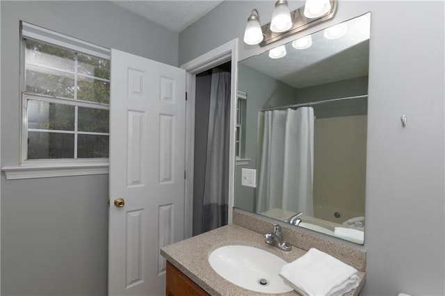 bathroom featuring vanity, shower / bath combo, and a textured ceiling