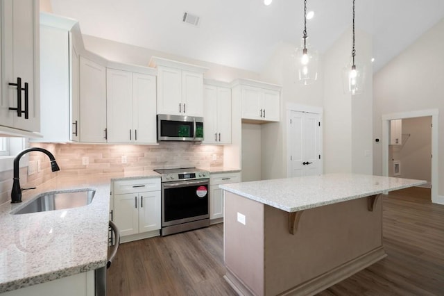 160 Doris Path, Dallas, GA 30157 - kitchen with stainless steel appliances, a sink, white cabinetry, a center island, and backsplash