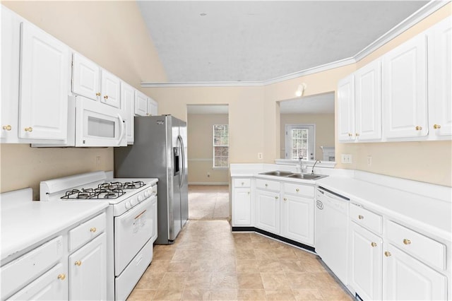 kitchen with white appliances, white cabinets, ornamental molding, and sink