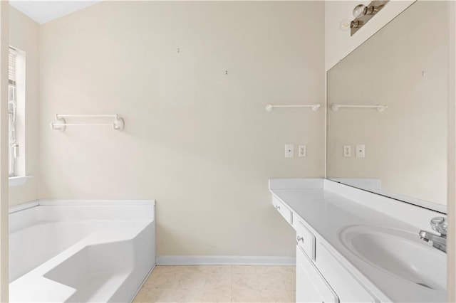 bathroom with a washtub, a wealth of natural light, and vanity