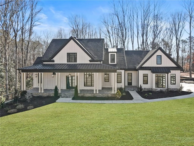 back of property featuring a standing seam roof, a shingled roof, a porch, and a yard