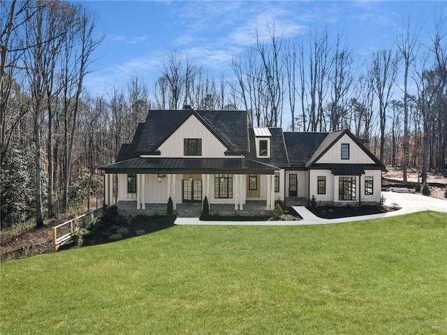 view of front of home with a standing seam roof, metal roof, and a front yard