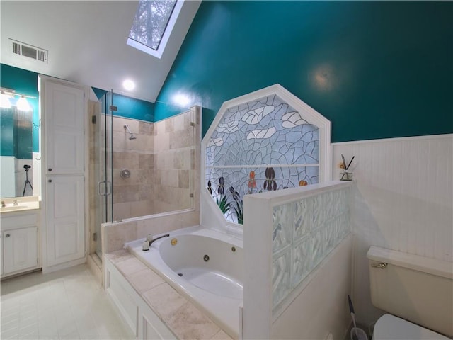 full bathroom featuring tile patterned floors, vaulted ceiling with skylight, vanity, independent shower and bath, and toilet