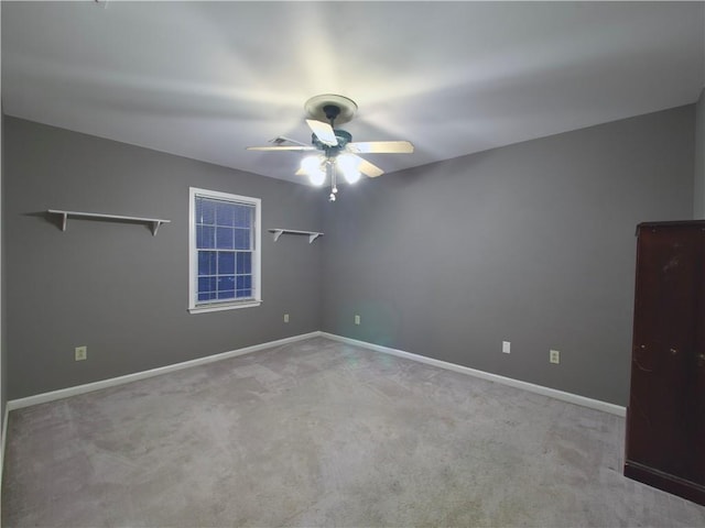 carpeted spare room featuring ceiling fan