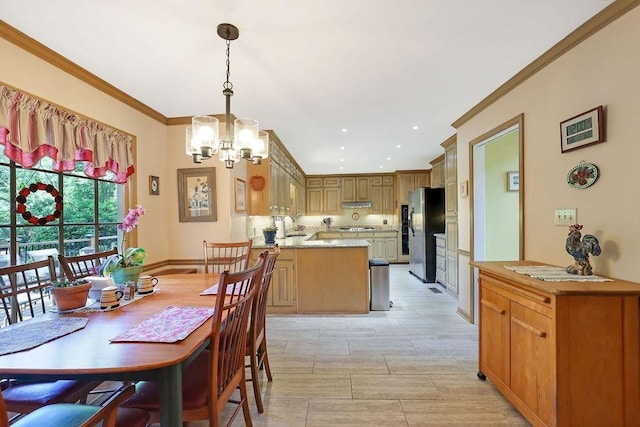 dining room featuring sink, crown molding, and an inviting chandelier