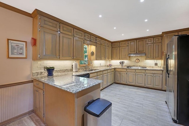 kitchen featuring sink, decorative backsplash, light stone counters, kitchen peninsula, and stainless steel appliances