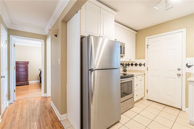 kitchen featuring decorative backsplash, appliances with stainless steel finishes, light wood-type flooring, crown molding, and white cabinets